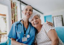 Home care healthcare professional hugging senior patient